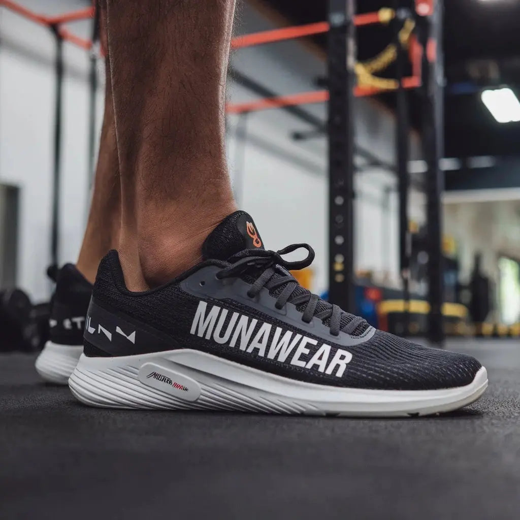 Close-up of a man wearing black MunaWear athletic sneakers at the gym, showcasing modern design and cushioned sole for performance training.