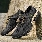 Black and beige shoes with gold accents on a stone surface